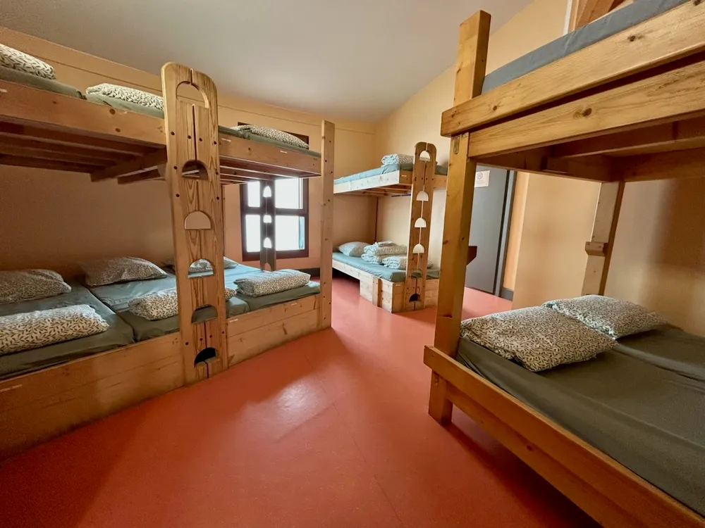 Un dortoir du refuge, avec ses lits superposés en bois et sa literie préparée